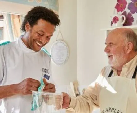 A nurse talking to an elderly nursing home resident - Applewood Healthcare