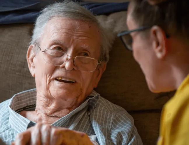 A member of staff talking to an elderly man in the care home - Applewood Healthcare