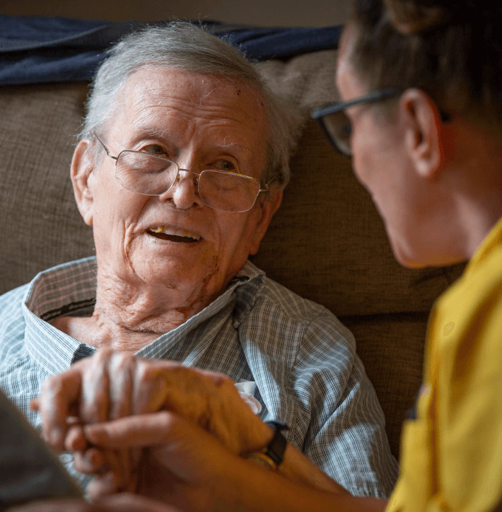 A member of staff talking to an elderly man in the care home - Applewood Healthcare