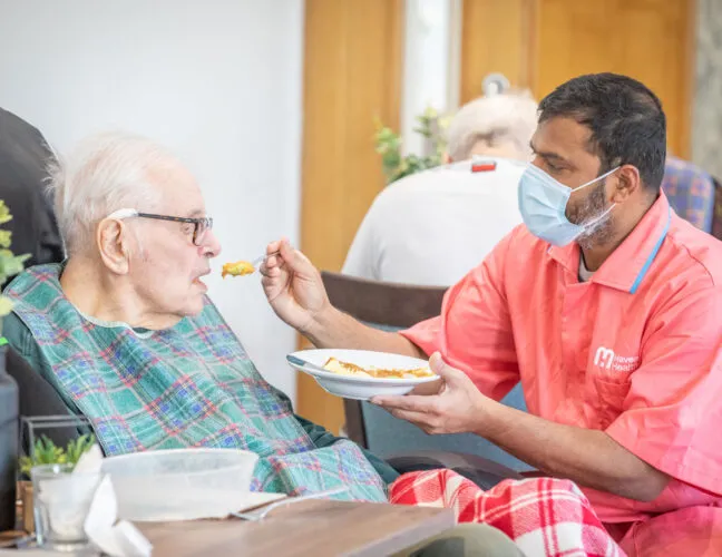 Nurse feeding an elderly resident - Applewood Healthcare