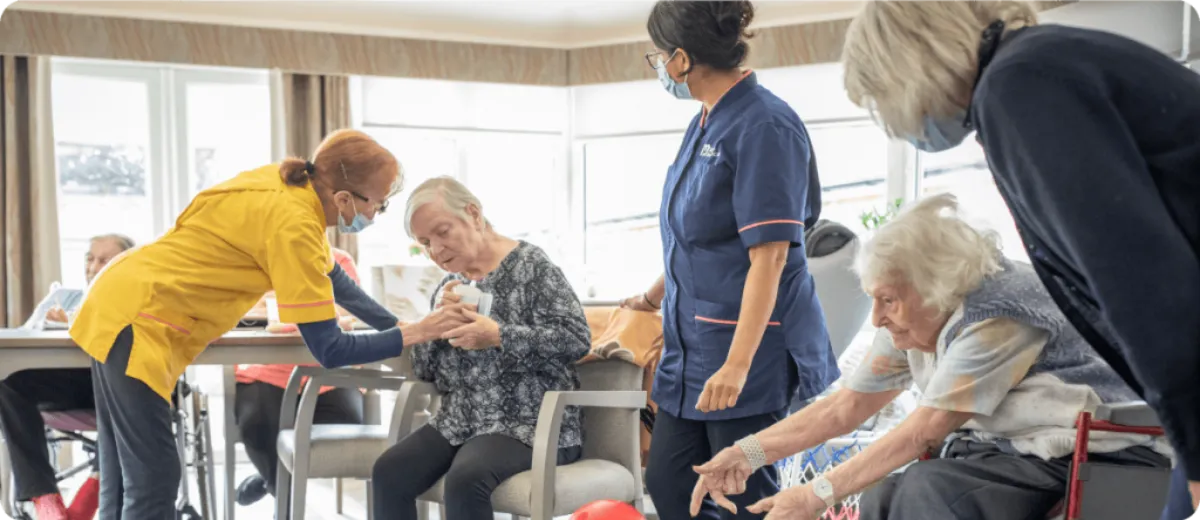 Nurses caring for elderly residents in the common room - Applewood Healthcare