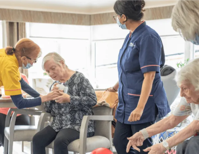 Nurses caring for elderly residents in the common room - Applewood Healthcare